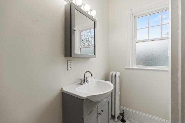 bathroom with a wealth of natural light, vanity, and radiator heating unit