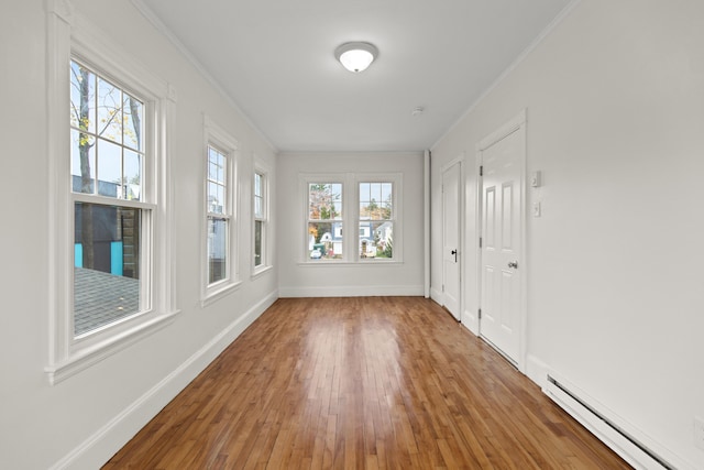 unfurnished sunroom with baseboard heating and plenty of natural light