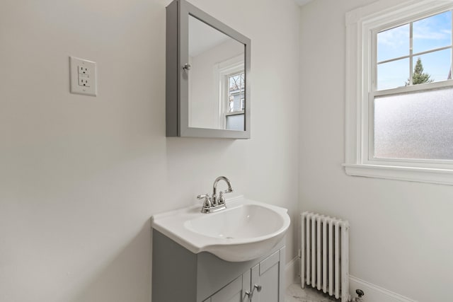 bathroom featuring radiator, vanity, and a wealth of natural light