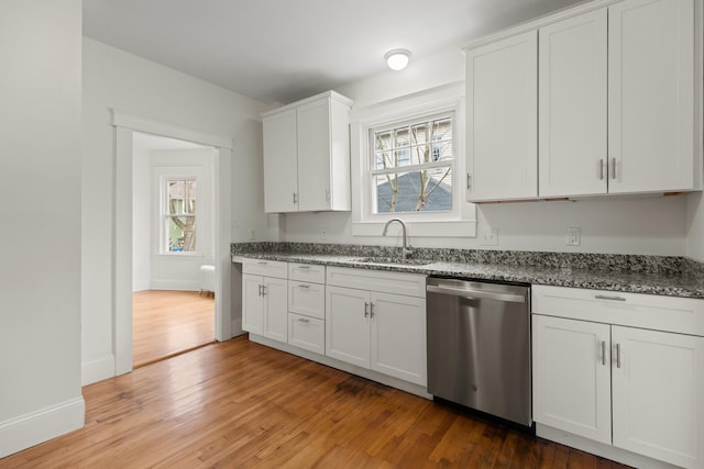 kitchen with dark stone counters, dishwasher, hardwood / wood-style floors, sink, and white cabinetry