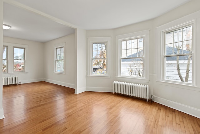 empty room featuring a wealth of natural light and radiator heating unit