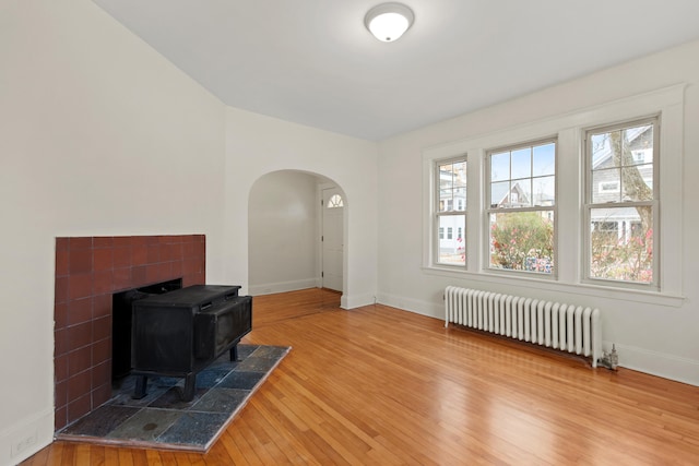 living room featuring a wood stove, wood-type flooring, and radiator