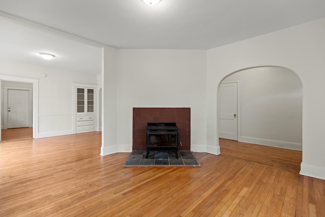 unfurnished living room featuring light wood-type flooring and a wood stove