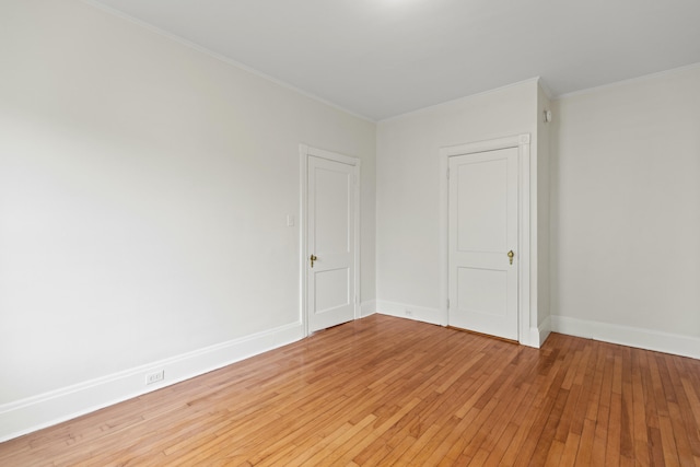 empty room featuring hardwood / wood-style floors and crown molding