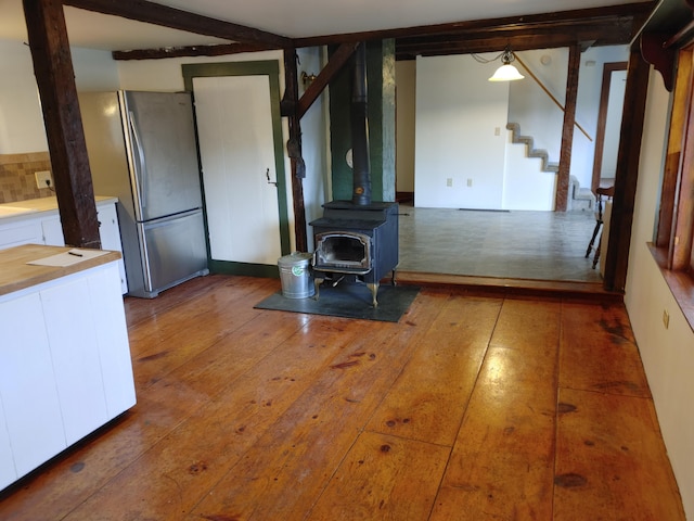 unfurnished living room with dark hardwood / wood-style floors and a wood stove