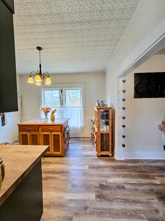 dining space with an inviting chandelier, hardwood / wood-style flooring, and crown molding