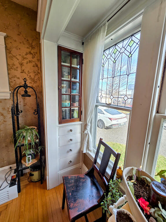 living area featuring ornamental molding, plenty of natural light, and wood-type flooring