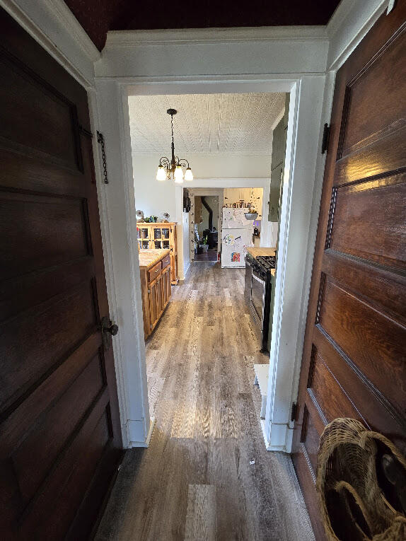 hallway featuring a chandelier, hardwood / wood-style floors, and a textured ceiling