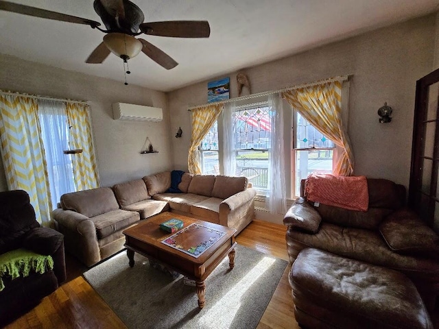 living room featuring ceiling fan, light wood-type flooring, and a wall mounted air conditioner