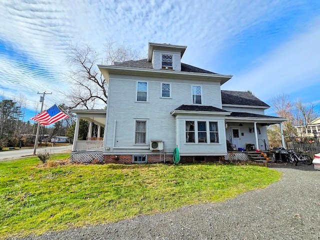 rear view of house with a yard, covered porch, and ac unit