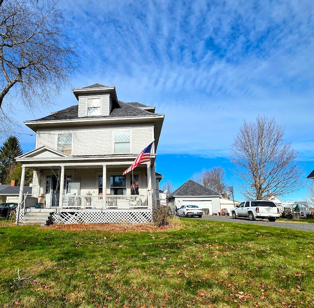 view of front of house featuring a garage, covered porch, and a front yard