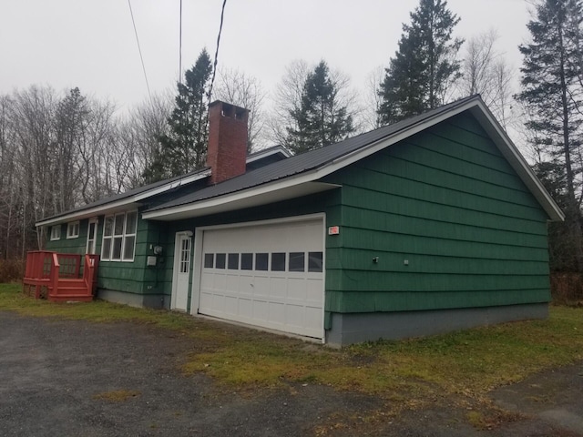 view of home's exterior with a wooden deck and a garage