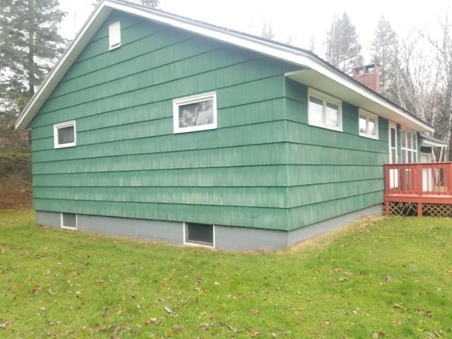 view of side of property with a deck and a yard