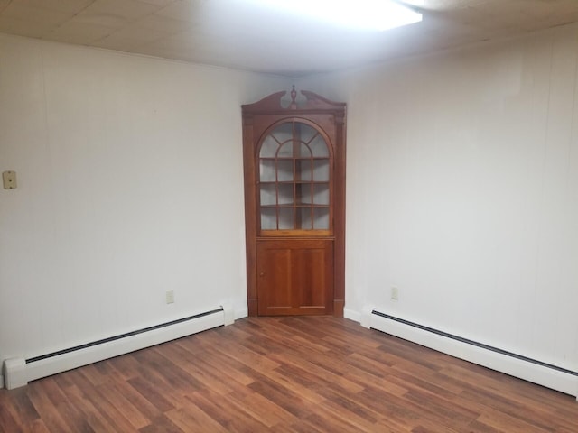 unfurnished room featuring a baseboard radiator and dark hardwood / wood-style floors