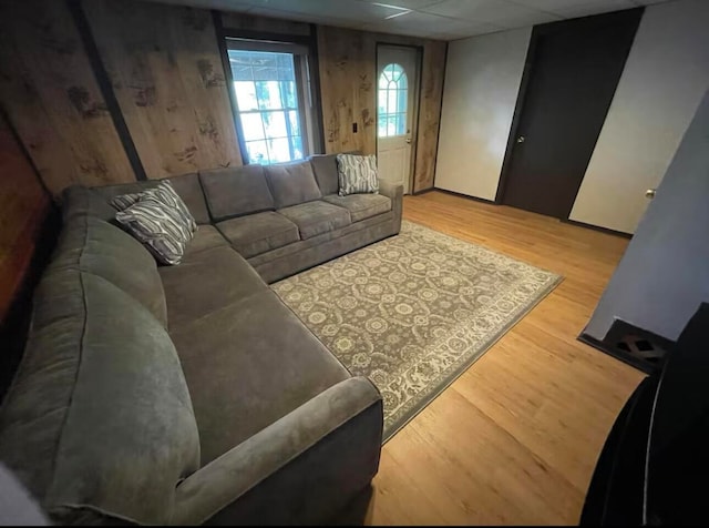 living room featuring a paneled ceiling and wood-type flooring