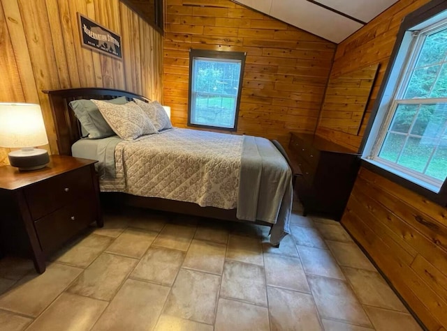 bedroom featuring wooden walls and vaulted ceiling