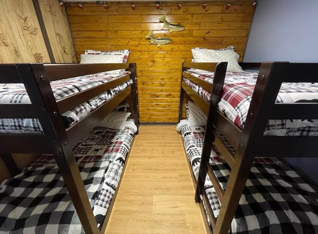 bedroom with wood walls and wood-type flooring