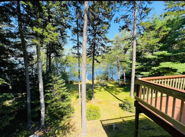 exterior space featuring a deck with water view and a yard