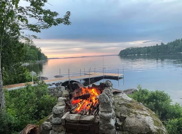 dock area with a water view and a fire pit