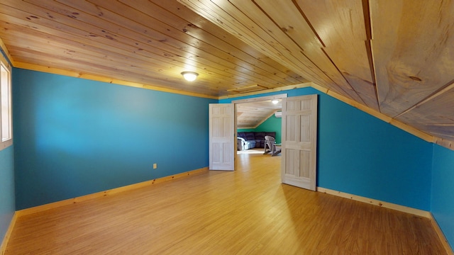 additional living space with hardwood / wood-style flooring, vaulted ceiling, and wooden ceiling