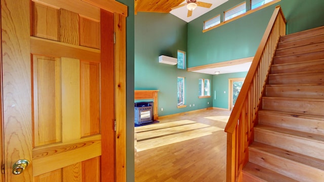 stairs featuring high vaulted ceiling, hardwood / wood-style flooring, and ceiling fan