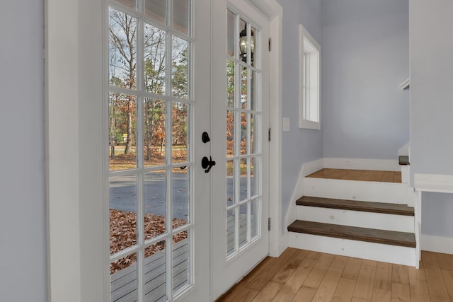 doorway with french doors and light hardwood / wood-style flooring