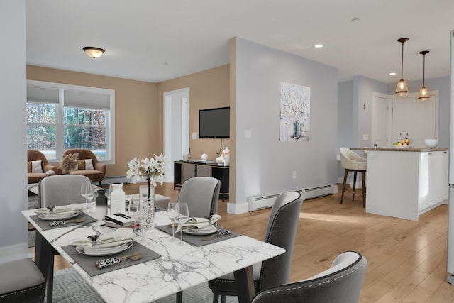 dining area featuring light hardwood / wood-style flooring and a baseboard heating unit