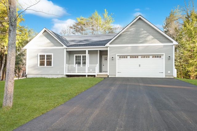 single story home with a garage, a front yard, and a porch