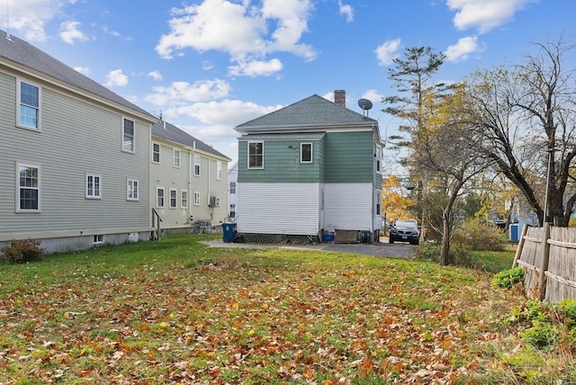 rear view of property with a lawn