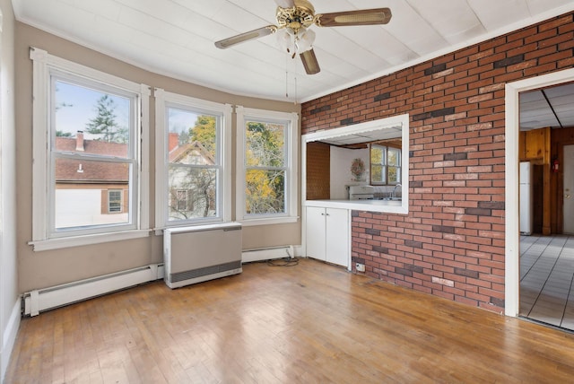 unfurnished sunroom featuring baseboard heating and ceiling fan