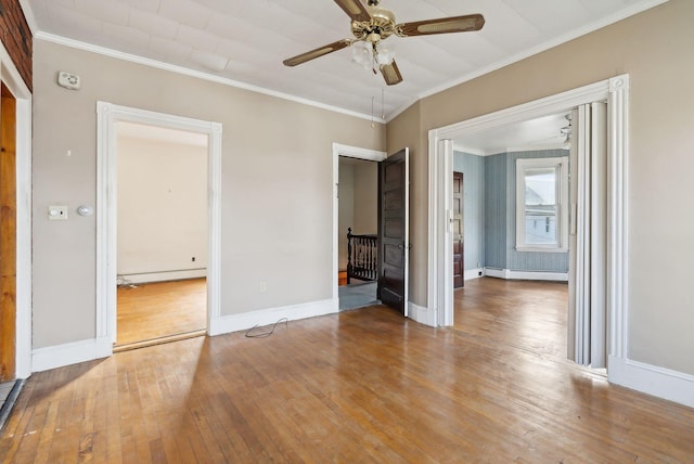 spare room with ceiling fan, baseboard heating, light hardwood / wood-style flooring, and crown molding