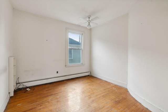 spare room featuring a baseboard heating unit, light hardwood / wood-style flooring, and ceiling fan