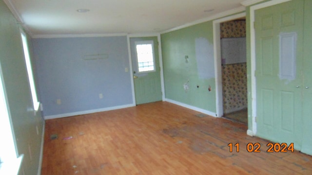 unfurnished room with hardwood / wood-style floors and crown molding