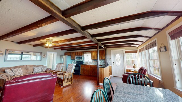 living room with dark wood-type flooring, beamed ceiling, and ceiling fan