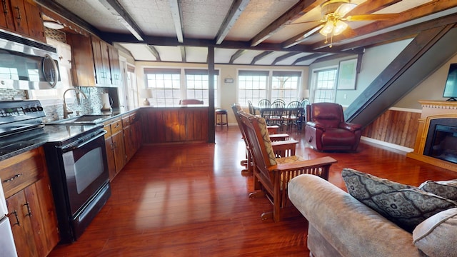 kitchen with wood walls, sink, ceiling fan, dark hardwood / wood-style floors, and black electric range oven