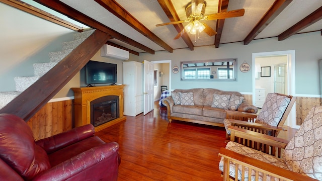 living room featuring hardwood / wood-style floors, wooden walls, beam ceiling, and an AC wall unit