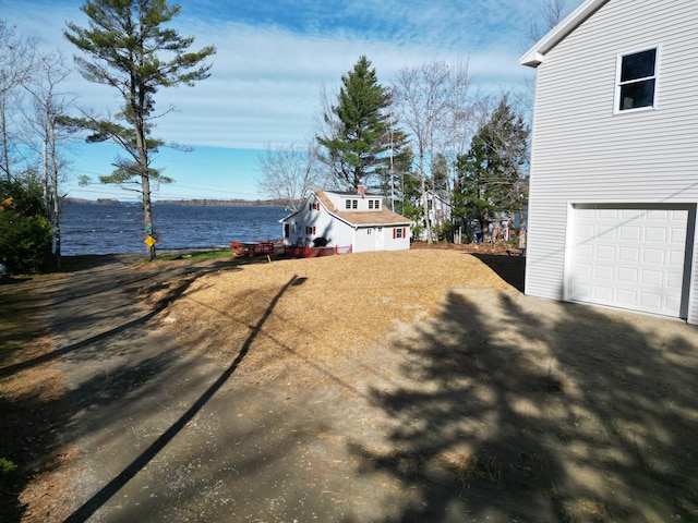 view of yard with a garage and a water view