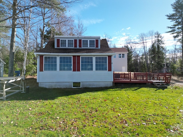 back of property with a wooden deck and a yard