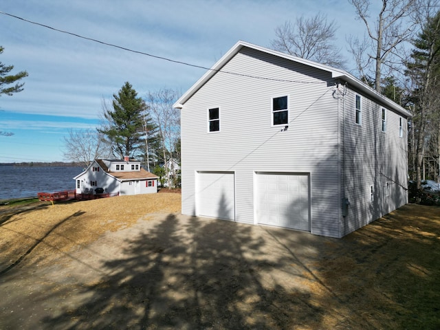 view of side of property with a garage and a water view