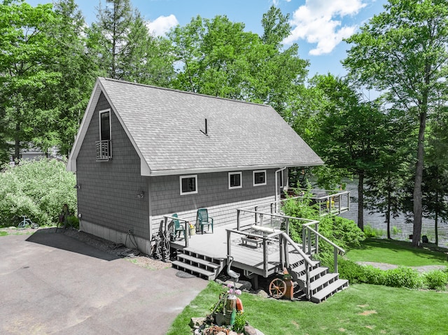 back of house featuring a lawn and a deck