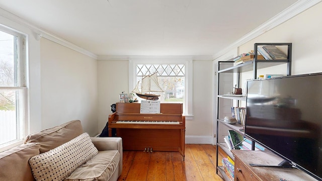 sitting room with hardwood / wood-style floors, a healthy amount of sunlight, and ornamental molding