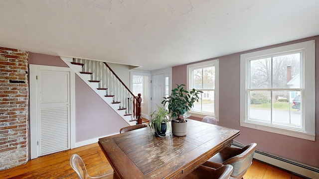 dining area with hardwood / wood-style flooring and a baseboard heating unit