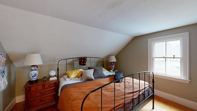 bedroom with hardwood / wood-style floors and vaulted ceiling