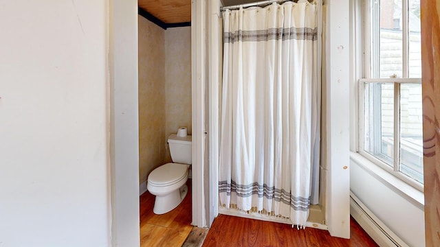 bathroom with a shower with shower curtain, wood-type flooring, toilet, and baseboard heating