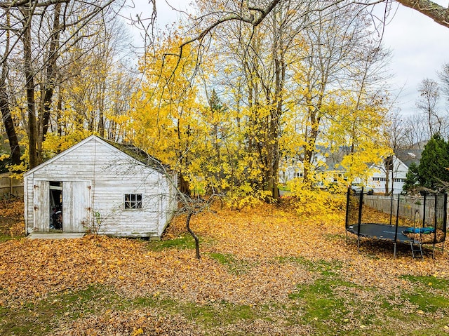 view of yard featuring a storage shed and a trampoline