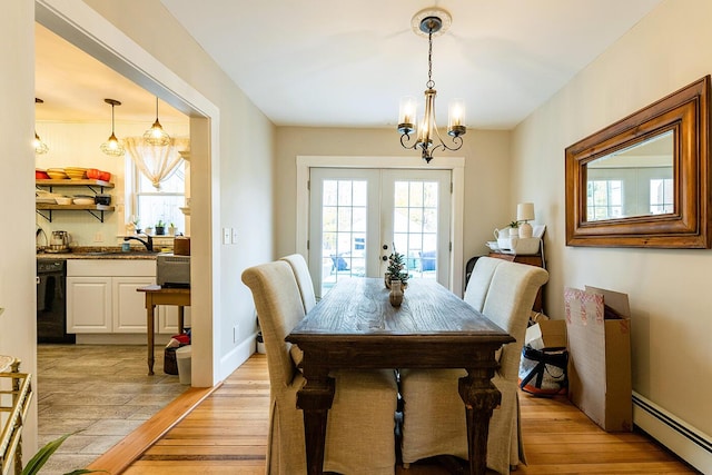 dining area featuring french doors, sink, a baseboard radiator, a notable chandelier, and light hardwood / wood-style floors