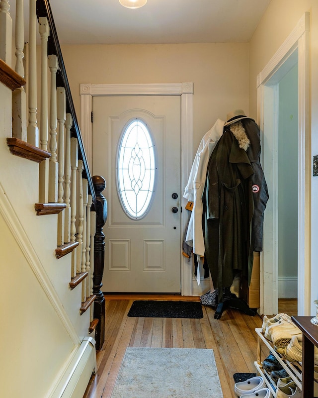 foyer with light wood-type flooring and a baseboard heating unit