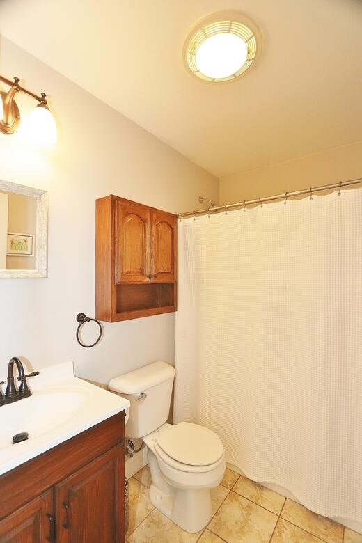 bathroom featuring toilet, vanity, and tile patterned floors