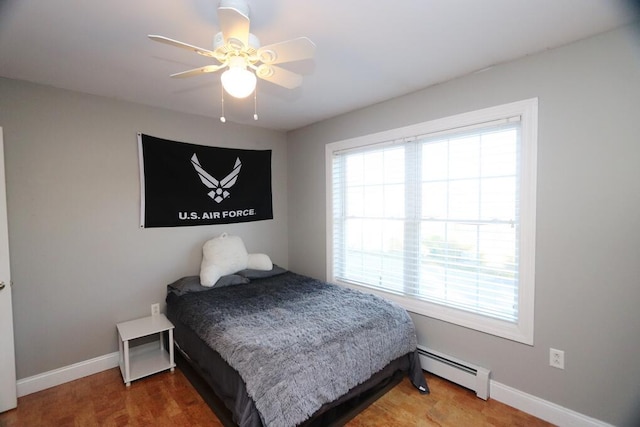 bedroom featuring ceiling fan and a baseboard heating unit