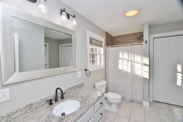 bathroom featuring tile patterned flooring, vanity, toilet, and curtained shower